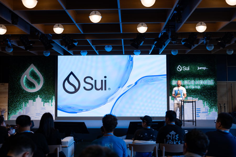 Sui Builder House Kyoto — main stage, brand screen, and hedge-wall set with audience