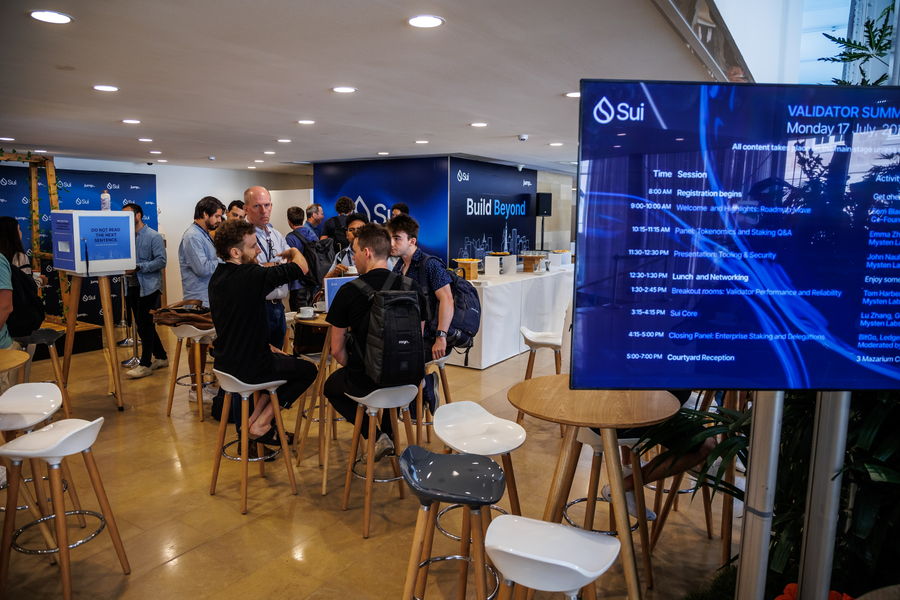 Sui Validator Summit Paris — networking lounge with schedule screen and “Build Beyond” wall